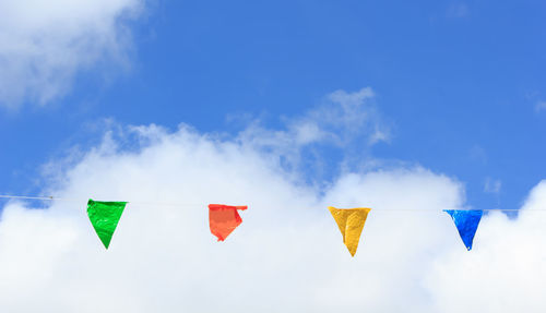 Close-up of multi colored hanging against sky