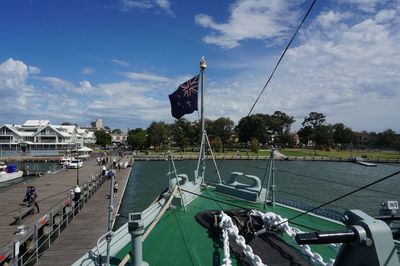 Boats moored at harbor against sky