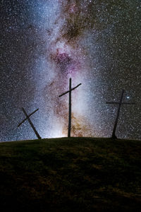 Low angle view of cross on grass at night