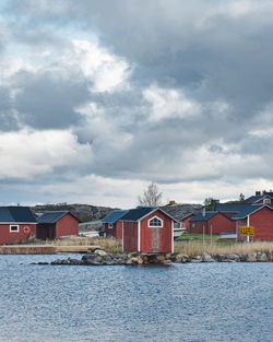 Houses by sea against sky