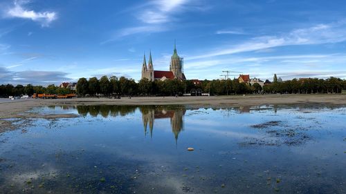 Reflection of building on lake against sky