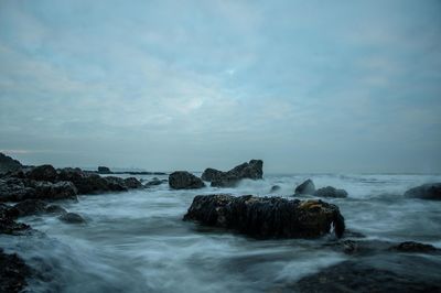 Rocks in sea against sky