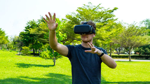 Man wearing virtual reality simulator while standing in park
