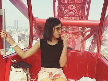 Young woman eating strawberry in hep five ferris wheel