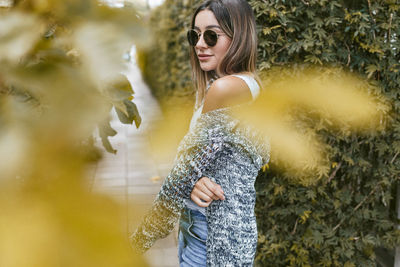 Portrait of young woman wearing sunglasses standing outdoors