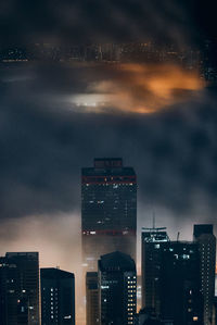 Illuminated buildings against sky at night