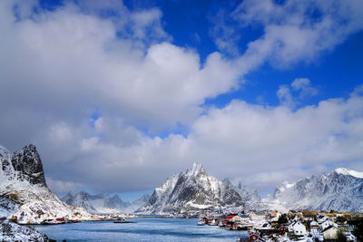 Scenic view of snowcapped mountains by sea against sky