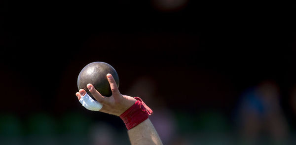 Cropped hand of athlete holding shot put