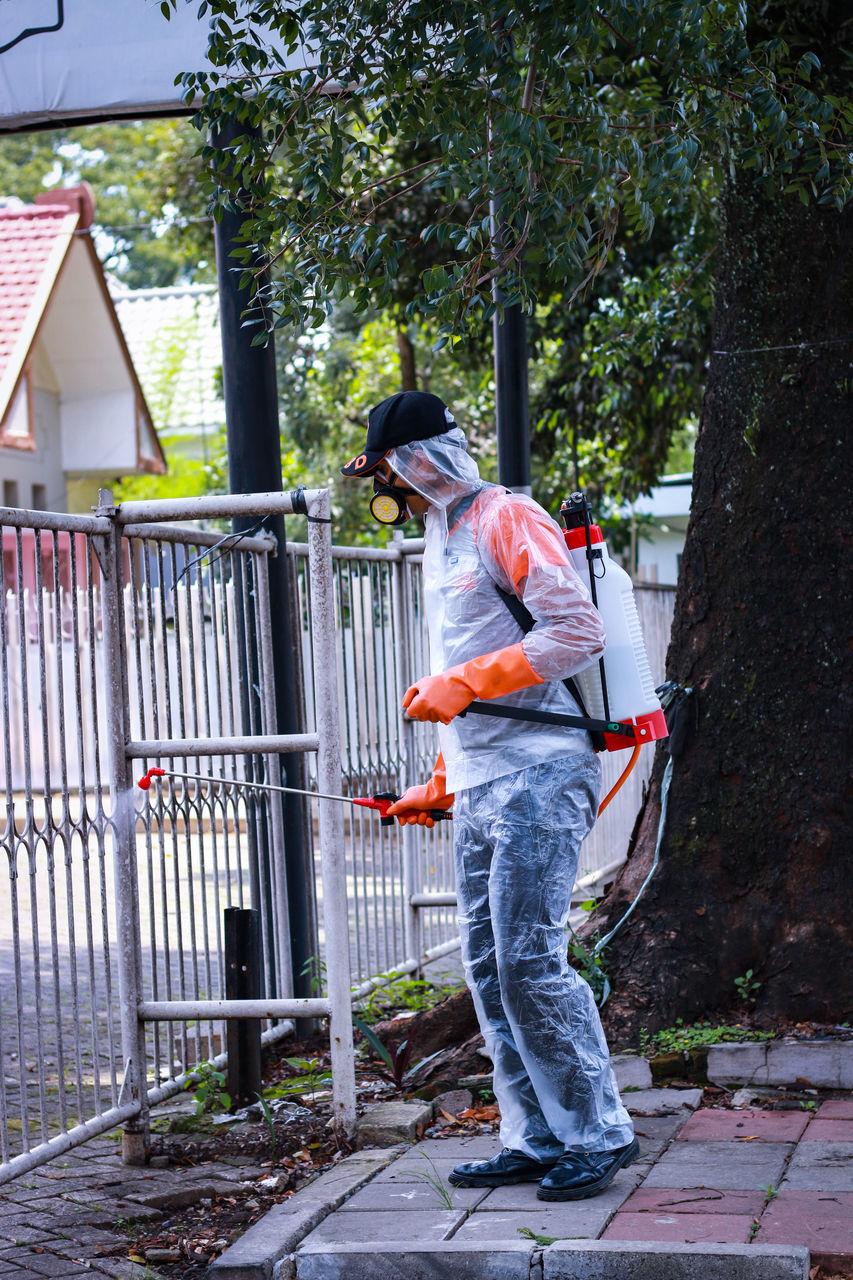 FULL LENGTH OF MAN STANDING BY TREE