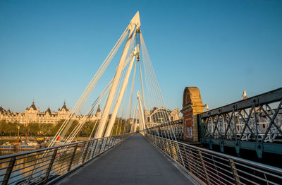 View of suspension bridge against blue sky