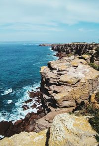 Rock formations by sea against sky