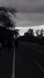 Empty road against cloudy sky