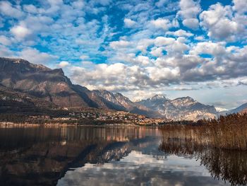 Scenic view of lake by mountains against sky