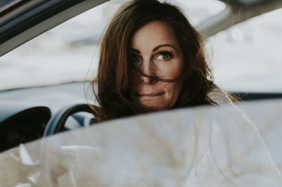 Woman looking away while sitting in car
