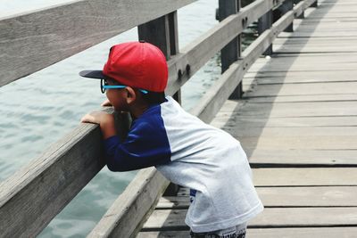 Side view of boy leaning railing