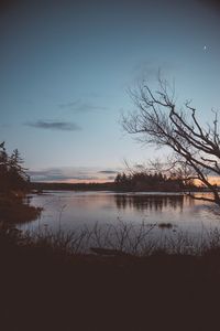 Scenic view of lake against sky at sunset