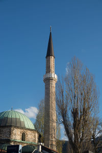 Minaret of gazi husrev-bey mosque against blue sky