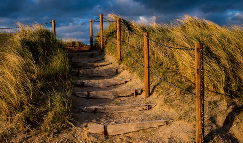 Staircase against cloudy sky