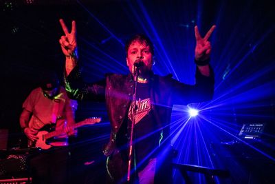 Midsection of man with illuminated lighting equipment in nightclub