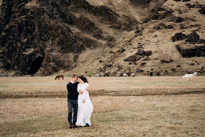 Rear view of couple standing on landscape