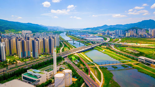 High angle view of city by buildings against sky