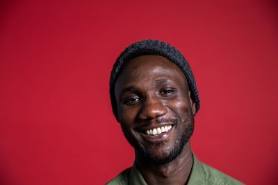 Portrait of a smiling man against red background