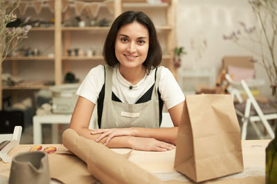 Portrait of smiling woman working at table