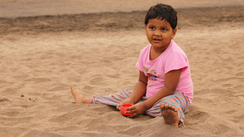 Girl sitting on sand at beach