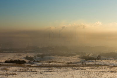 Scenic view of snowy field against sky during sunset