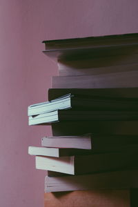 Close-up of books on table against wall