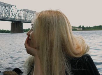 Portrait of woman against lake against sky