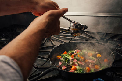 Cropped hands of man preparing food in kitchen