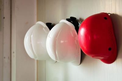 Close-up of helmets hanging on wooden wall