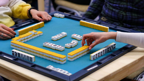 A mahjong table with an active game and the hands of the participants in the game.