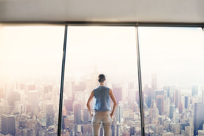 Rear view of man standing by modern buildings in city