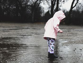 Rear view of girl walking in water