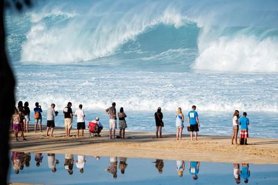 People at beach against sky
