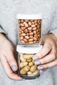 Midsection of woman holding food jars