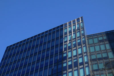 Low angle view of modern building against clear blue sky