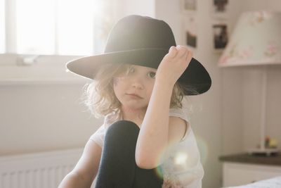 Portrait of a young girl holding her hat with her face painted