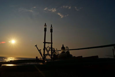 Oil lamps against sky during sunset