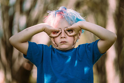 Young boy making upside down hand glasses