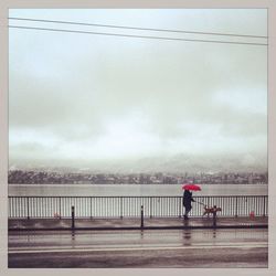 People in water against cloudy sky