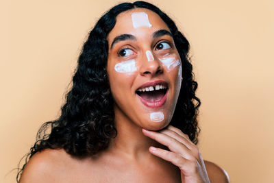 Portrait of young woman against yellow background