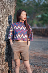 Low section of woman standing against wall