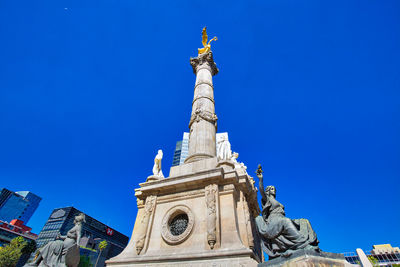 Low angle view of statue against blue sky