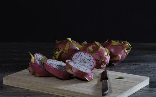 Close-up of fruits on table against black background