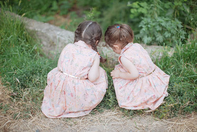 Rear view of girl sitting on grass