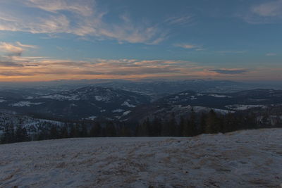 Scenic view of snow covered mountains against sky during sunset