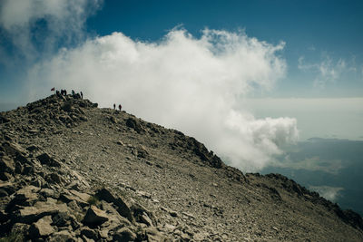 Low angle view of people on mountain against sky